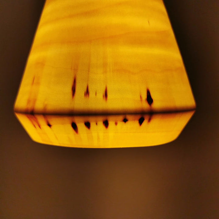 gelblich leuchtende Lampe aus Pappelholz, im detail