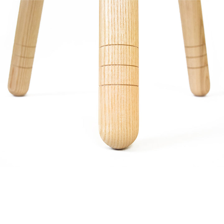 Detail von den drei Beinen von einem Hocker aus Holz