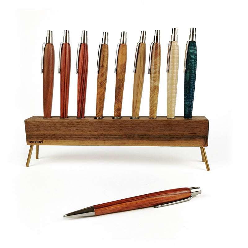 Neun Holzkugelschreiber in verschiedenen Holzarten in einem Stiftehalter